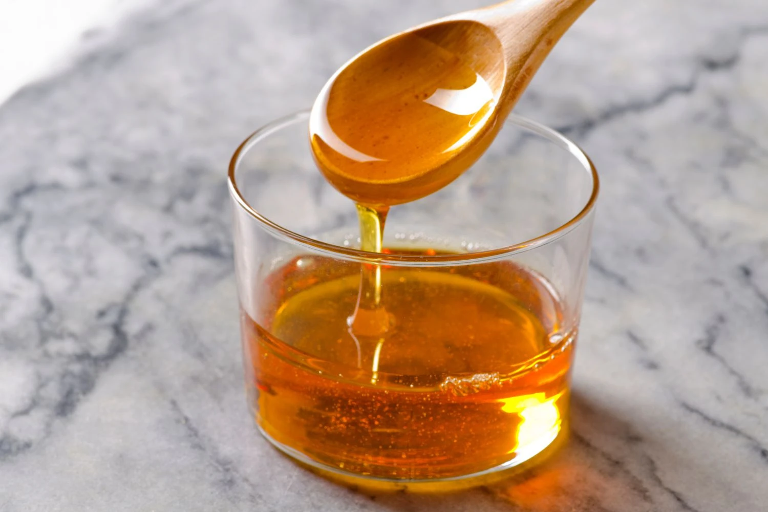 a wooden spoon dripping with honey